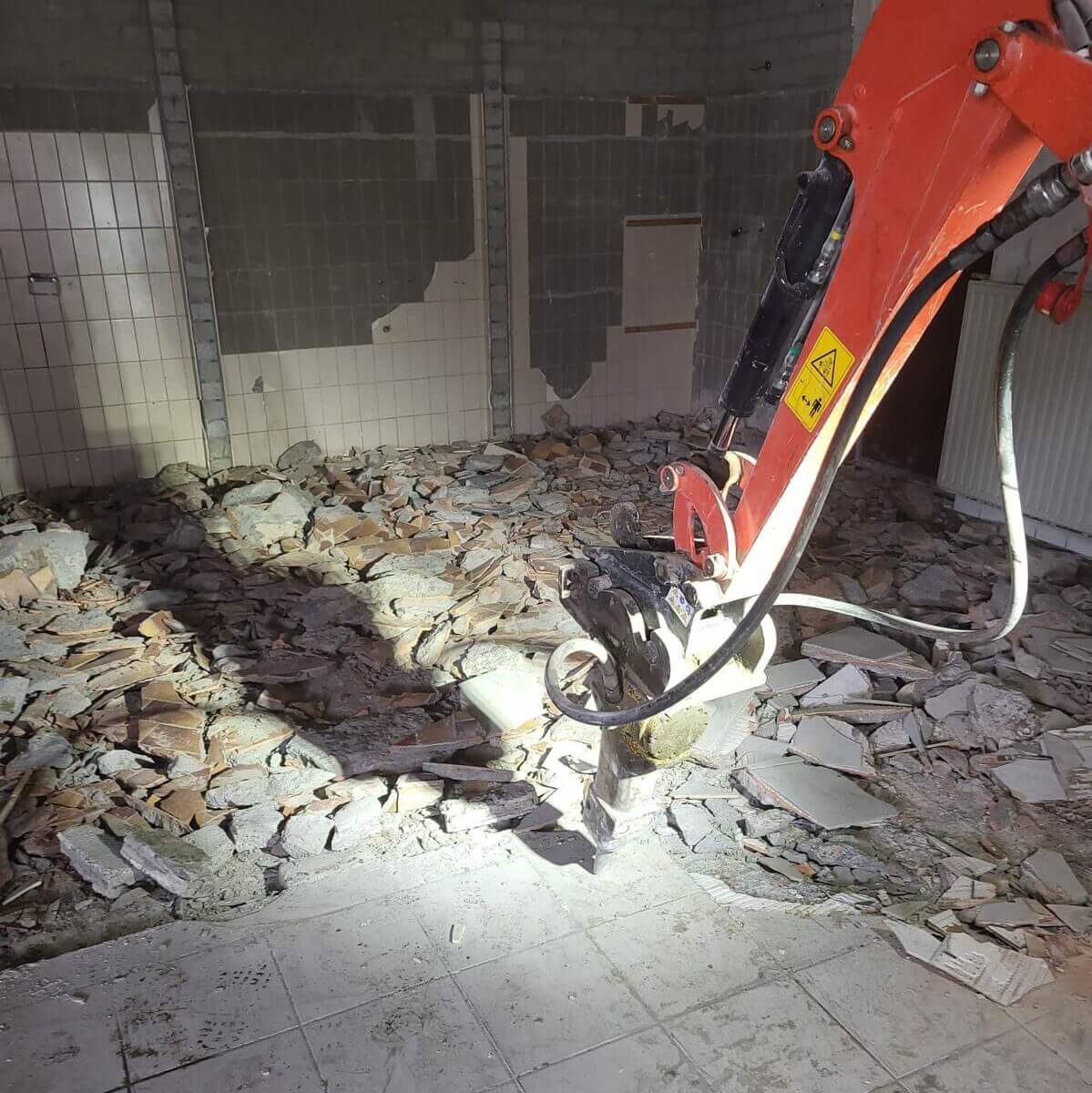 Betonvloer verwijderen met sloopkraan